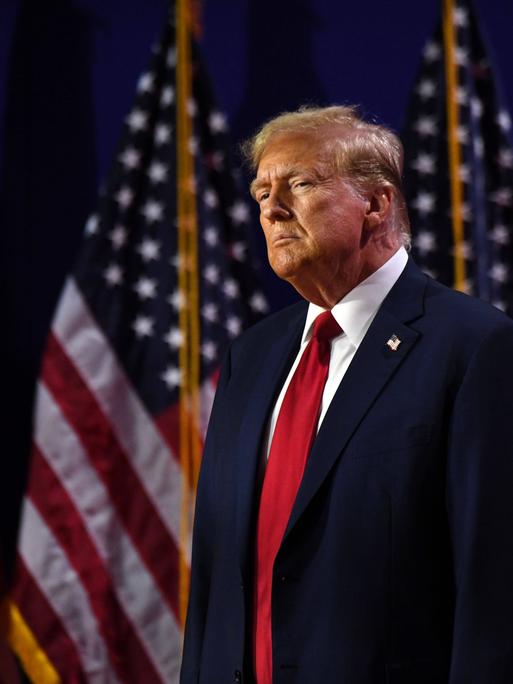 Der ehemalige Präsident Donald Trump steht vor US-Flaggen auf der Road to Majority Conference in Washington DC am 22. Juni 2024.