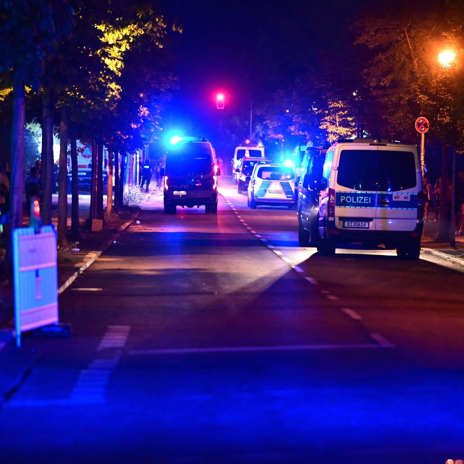 Einsatzkräfte und Fahrzeuge der Polizei auf einer nächtlichen Straße. 