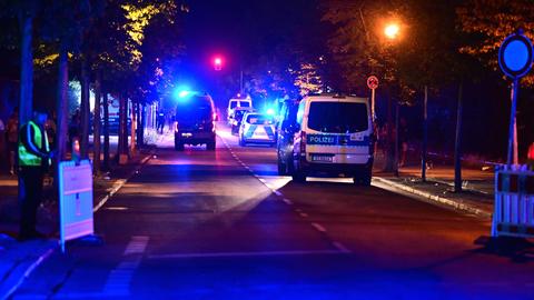 Einsatzkräfte und Fahrzeuge der Polizei auf einer nächtlichen Straße. 