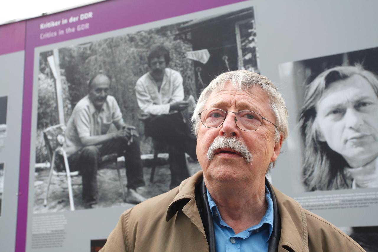 Wolf Biermann vor einem Schwarz-Weiß-Foto von sich und dem Chemiker und Kommunisten Robert Havemann in dessen Garten in einer Open-Air-Ausstellung auf dem Alexanderplatz 2010
