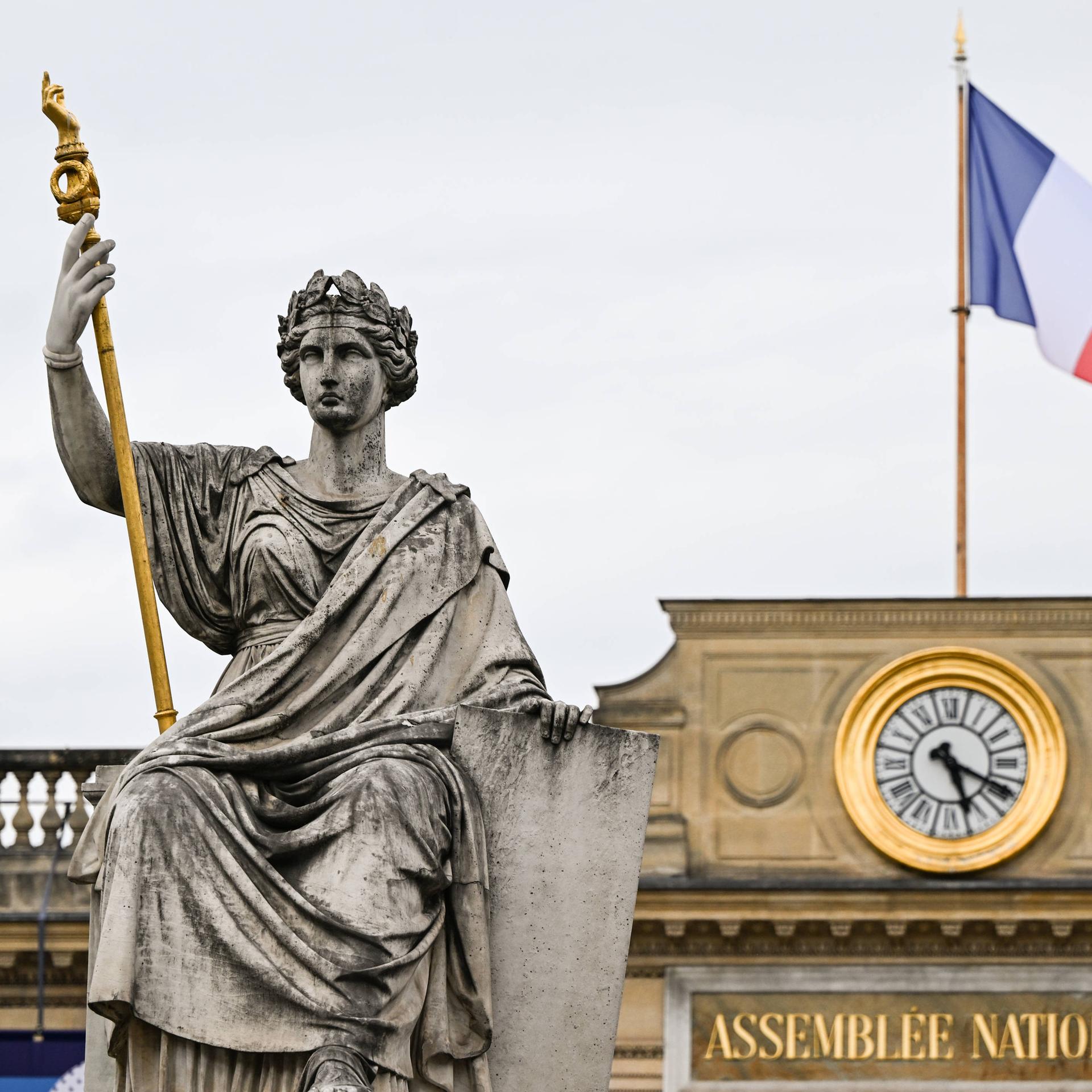 Die Statue der Marianne vor dem Gebäude der Nationalversammlung in Paris, auf dessen Dach die französische Flagge weht 