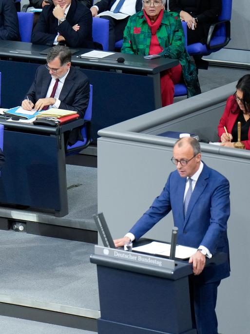 Bei der 199. Sitzung des deutschen Bundestages spricht CDU-Chef Friedrich Merz, während daneben einige Regierungsmitglieder sitzen, darunter Bundeskanzler Olaf Scholz