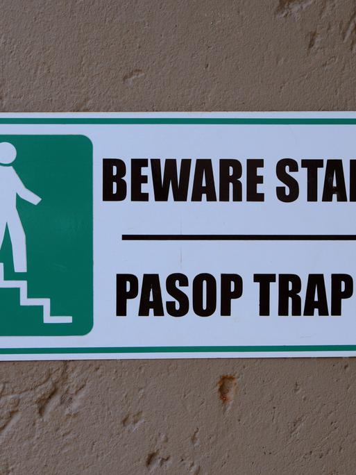 Ein zweisprachiges Warnschild an einem Gebäude in Pretoria macht auf eine Treppe aufmerksam