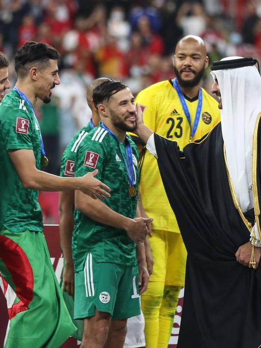 Scheich Tamim bin Hamad Al Thani, der Emir von Katar tätschelt die Wange des algerischen Spielers Mohammed Balaili.
