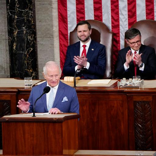 König Charles steht am Redepult im US-Kongress und hält eine Rede. Hinter ihm applaudieren Speaker Mike Johnson und Vize-Präsident Vance. Königin Camilla sitzt daneben.