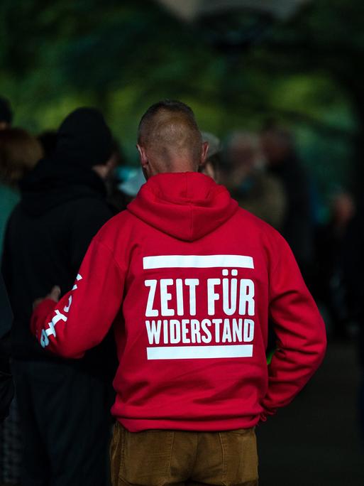 Ein Teilnehmer einer Wahlkampfveranstaltung trägt einen roten Pullover mit der Aufschrift "Zeit für Widerstand".