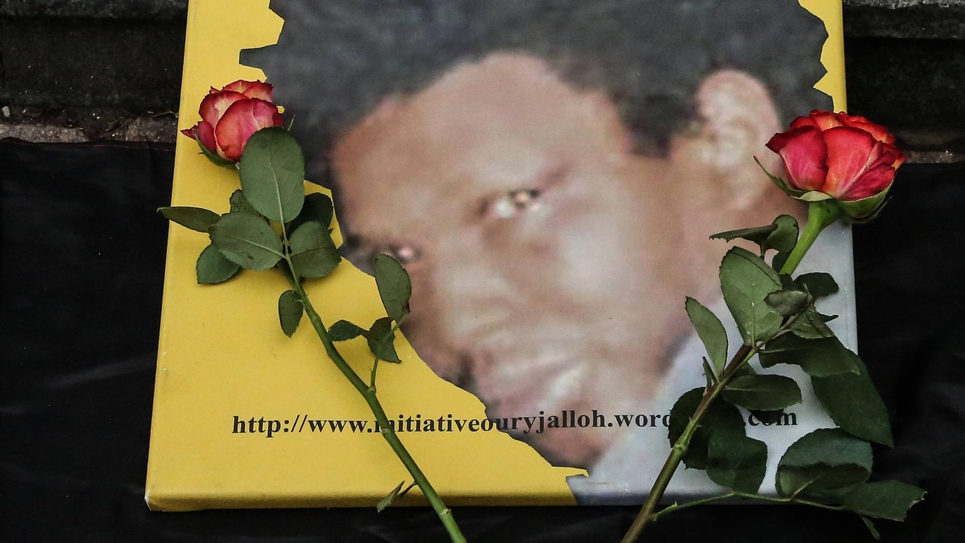 Das Foto von Oury Jalloh, daneben liegen zwei rote Rosen. Bei einer Gedenk-und Protestdemo am 07.01.2018 in Dessau.