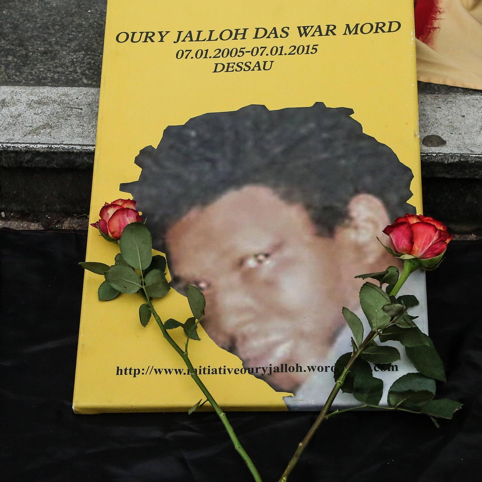 Das Foto von Oury Jalloh, daneben liegen zwei rote Rosen. Bei einer Gedenk-und Protestdemo am 07.01.2018 in Dessau.