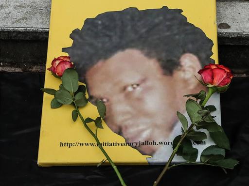 Das Foto von Oury Jalloh, daneben liegen zwei rote Rosen. Bei einer Gedenk-und Protestdemo am 07.01.2018 in Dessau.