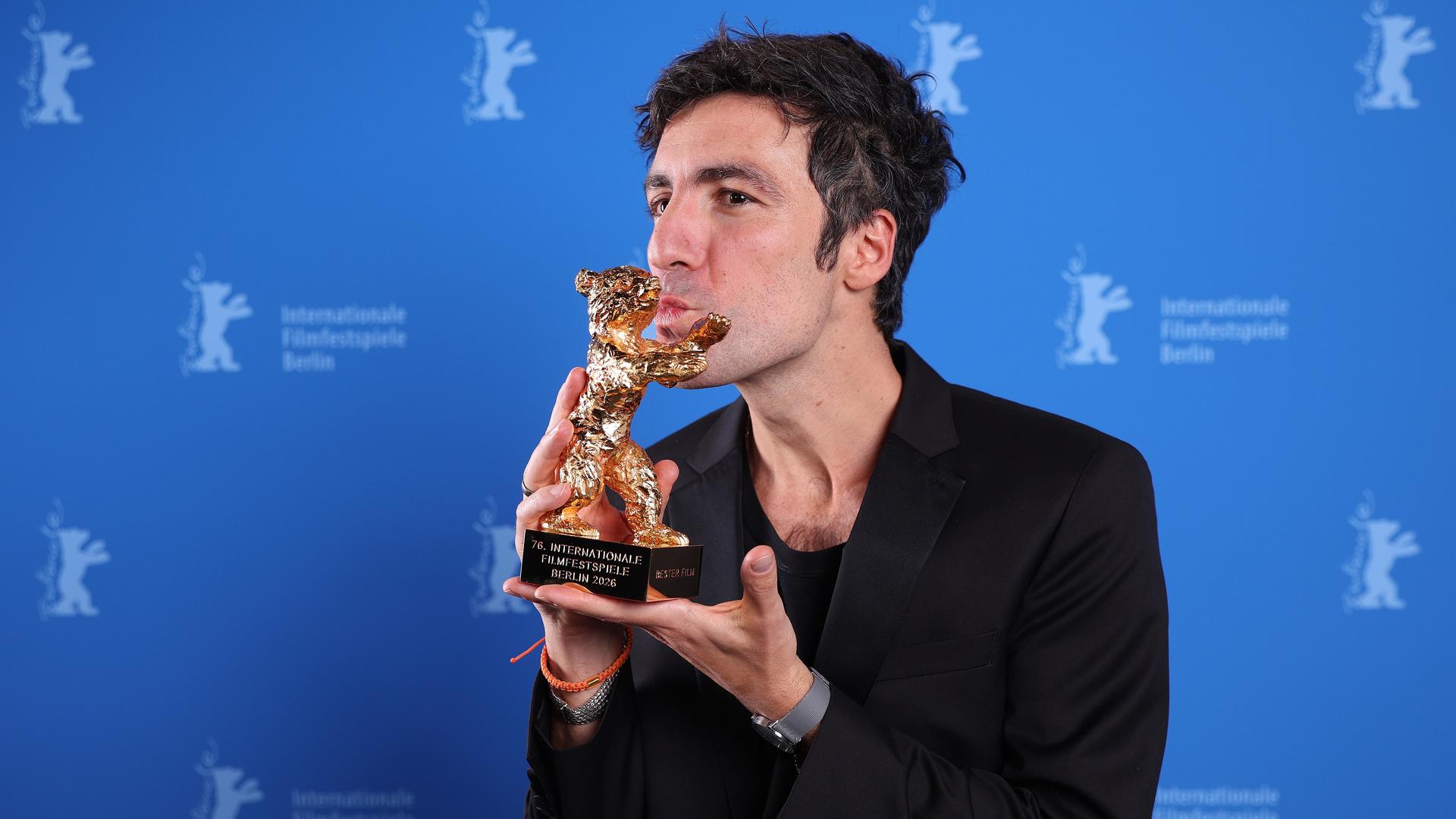 Ilker Catak küsst auf der Bühne von der Berlinale seinen Preis.