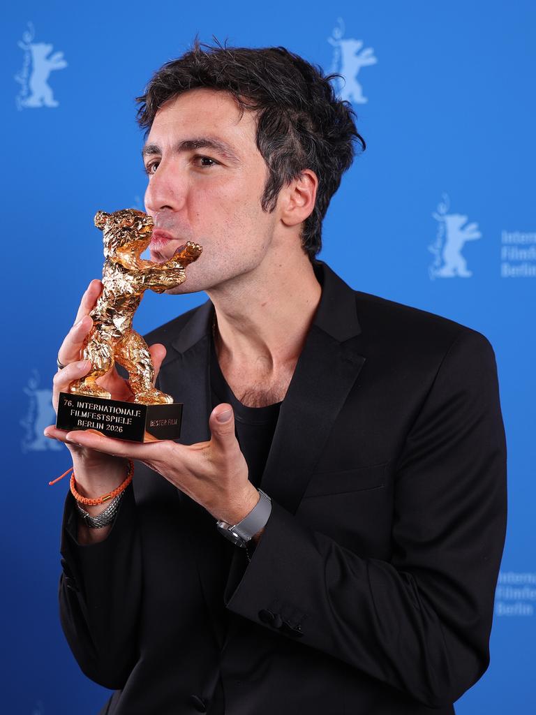 Ilker Catak küsst auf der Bühne der Berlinale die Statuette des Goldenen Bären.