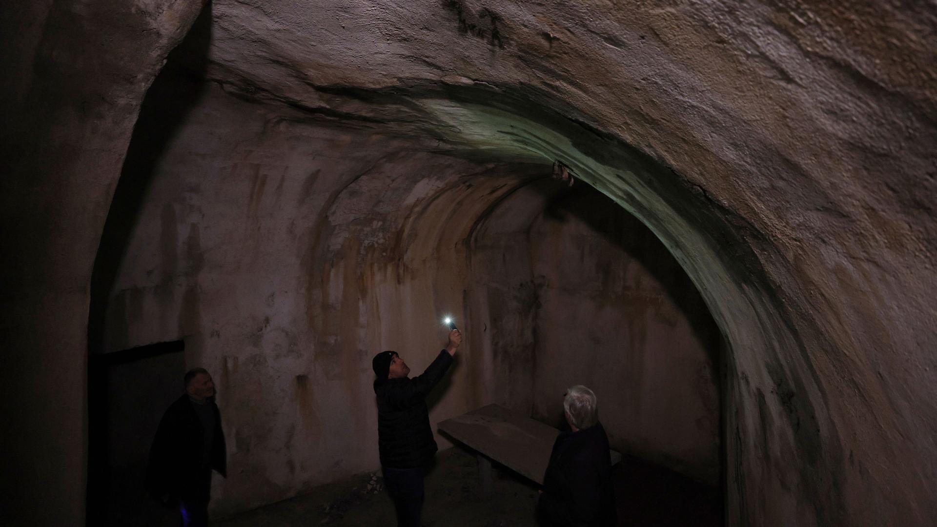 Ein Touristenführer beleuchtet mit seinem Handy einen Tunnel unter der albanischen Stadt Kukës. Ein Touristenführer beleuchtet mit seinem Handy einen Tunnel unter der albanischen Stadt Kukës.