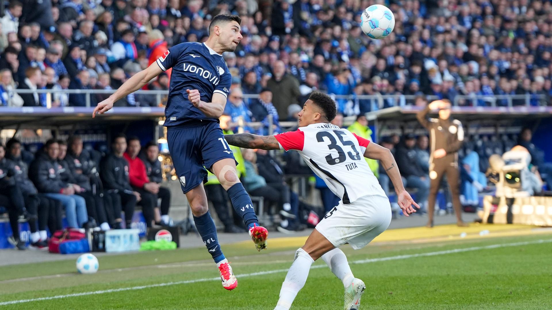Beim Bundesliga-Spiel Bochum gegen Frankfurt ist ein Kopfballduell zwischen Georgios Masouras vom VfL Bochum und Tuta Lucas Silva Melo von Eintracht Frankfurt zu sehen. Beim Bundesliga-Spiel Bochum gegen Frankfurt ist ein Kopfballduell zwischen Georgios Masouras vom VfL Bochum und Tuta Lucas Silva Melo von Eintracht Frankfurt zu sehen.