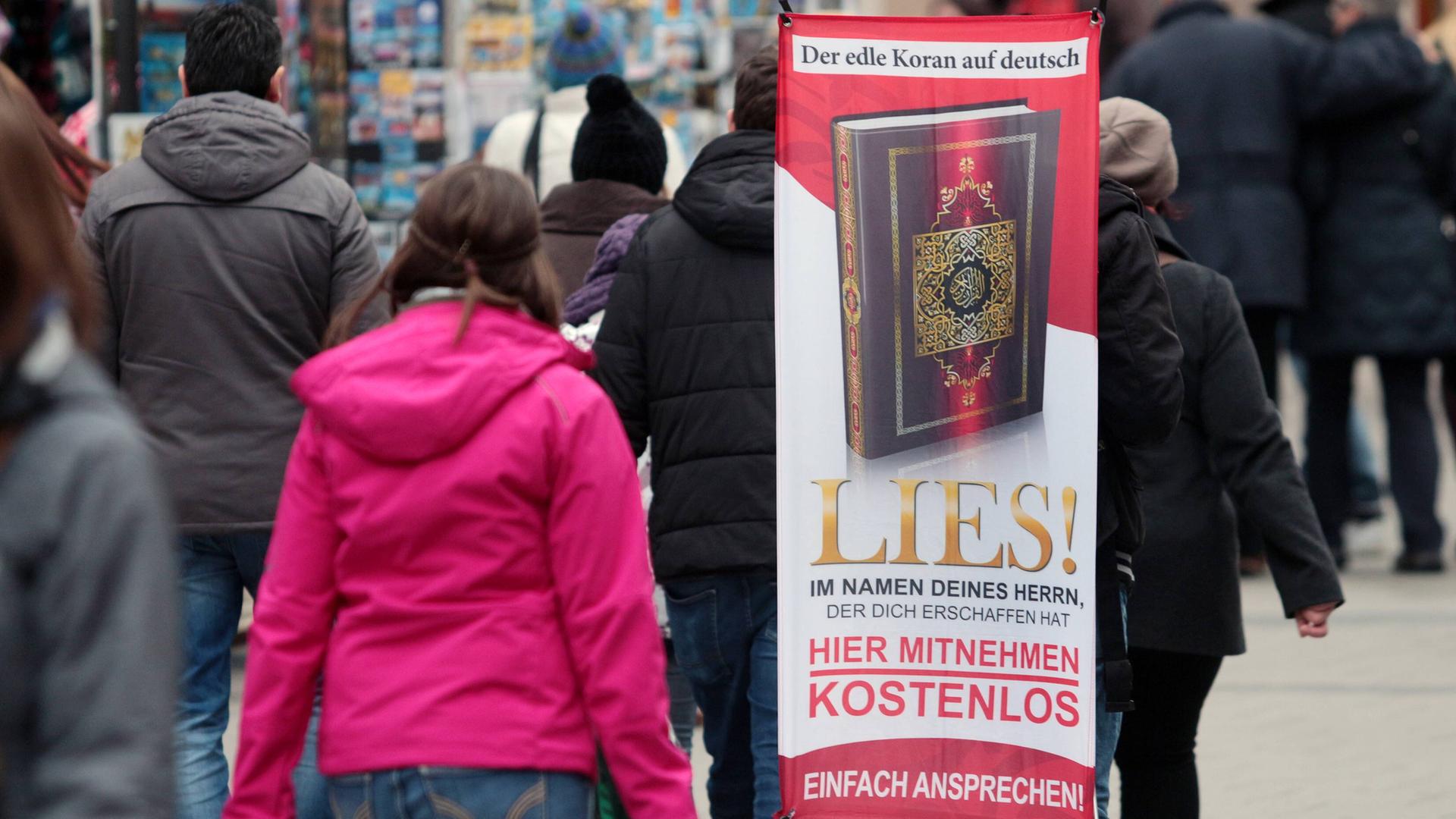 Ein Mensch läuft mit einem Transparent durch die Münchner Innenstadt: "Der edle Koran auf deutsch. Lies im Namen des Herrn, der dich erschaffen hat. Hier Mitnehmen kostenlos. Lies!" Ein Mensch läuft mit einem Transparent durch die Münchner Innenstadt: "Der edle Koran auf deutsch. Lies im Namen des Herrn, der dich erschaffen hat. Hier Mitnehmen kostenlos. Lies!"