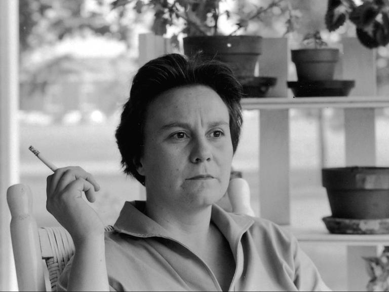 Ein Schwarz-Weiß-Filmausschnitt zeigt die Autorin Harper Lee rauchend auf einer Veranda. Ein Schwarz-Weiß-Filmausschnitt zeigt die Autorin Harper Lee rauchend auf einer Veranda.