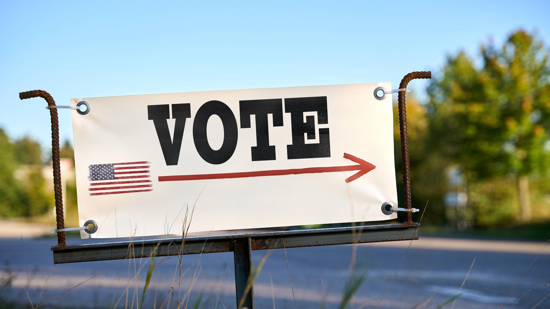 Am Straßenrand steht ein Schild auf dem "Vote" steht und die US-Flagge abgebildet ist (3. Oktober 2024)