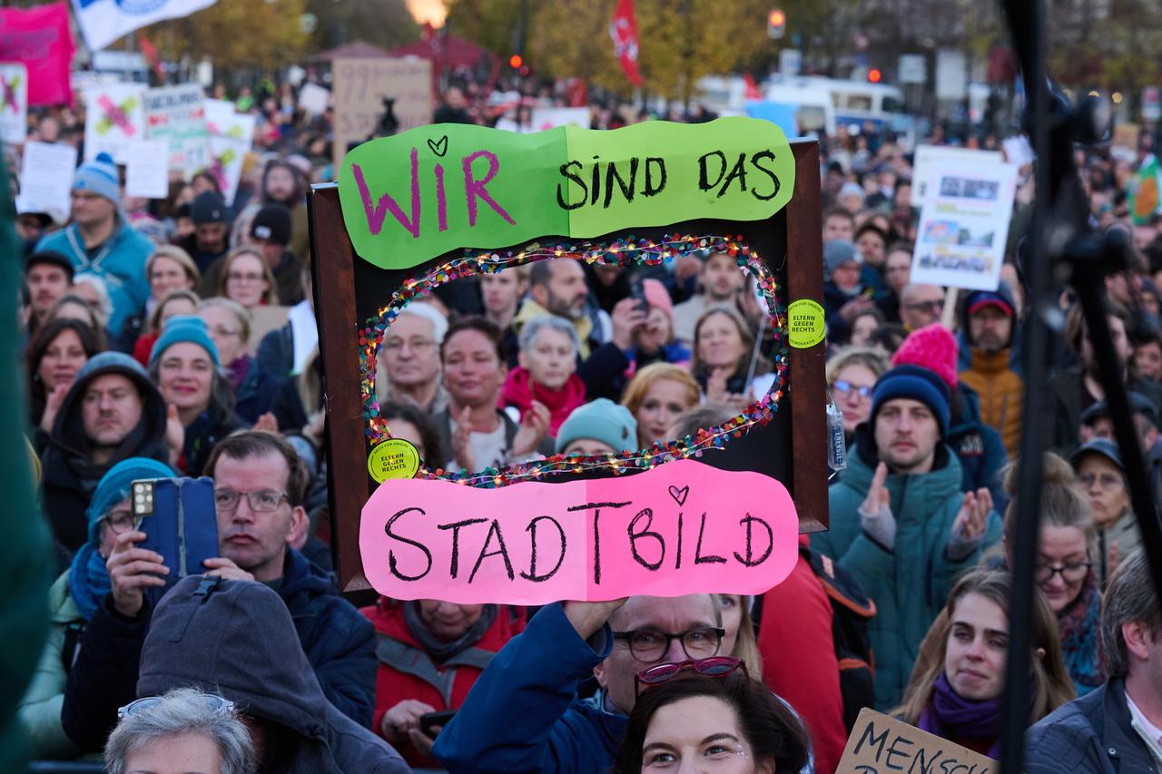 „Wir sind das Stadtbild“ steht auf einem Plakat, das ein Demonstrant vor dem Brandenburger Tor hält. Die Demonstration unter dem Motto «Brandmauer hoch! Wir sind das Stadtbild» bezieht sich auf eine Äußerung von Merz zur Migrationspolitik.