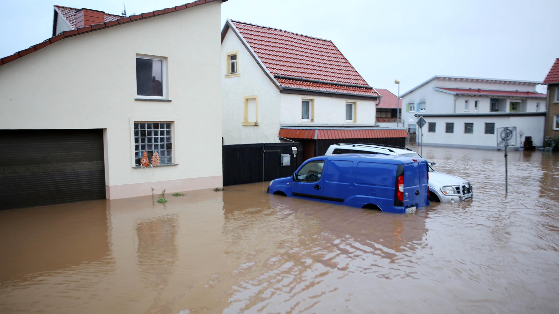 Das Bild zeigt eine Szene aus der Gemeinde Windehausen in Thüringen. Zwei Autos stehen in einer überfluteten Straße.