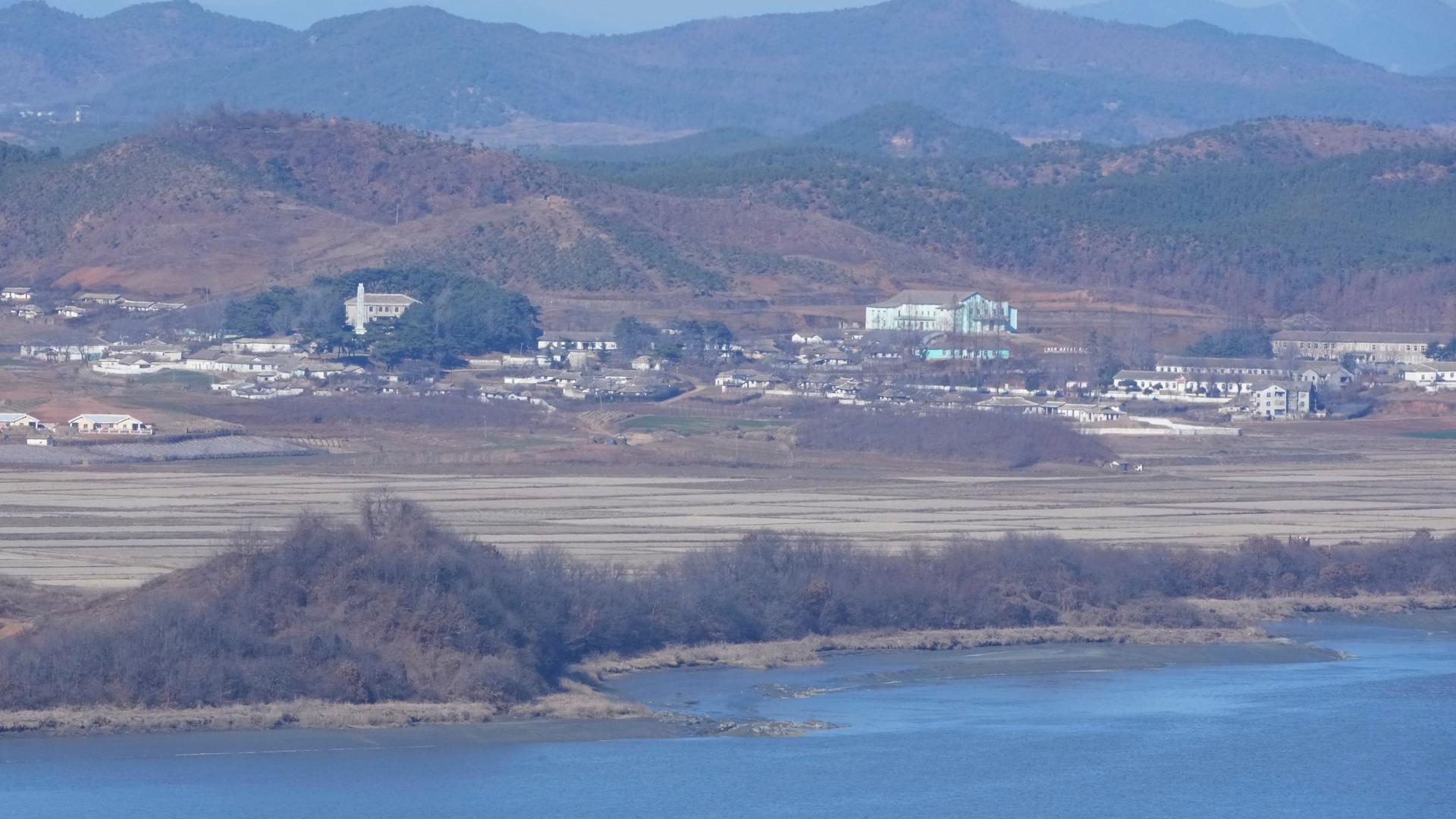 Das Bild zeigt Meer, die nordkoreanische Küste und die Stadt aus sehr großer Entfernung. Das Bild zeigt Meer, die nordkoreanische Küste und die Stadt aus sehr großer Entfernung.