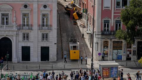 Menschen betrachten die entgleiste Standseilbahn in Lissabon.