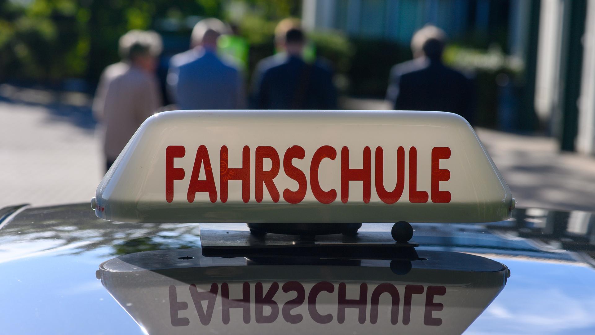 Nahaufnahme des Schilds "Fahrschule" auf dem Dach eines Autos. Nahaufnahme des Schilds "Fahrschule" auf dem Dach eines Autos.