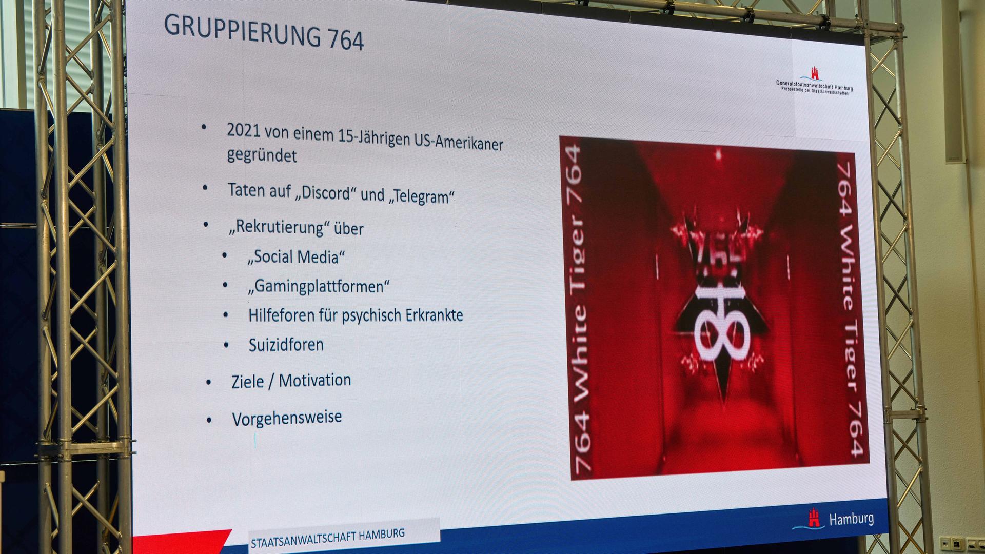 Auf einem Screen wird während einer Pressekonferenz von Polizei und Generalstaatsanwaltschaft eine Internetseite der Gruppierung 764 gezeigt. Auf einem Screen wird während einer Pressekonferenz von Polizei und Generalstaatsanwaltschaft eine Internetseite der Gruppierung 764 gezeigt.