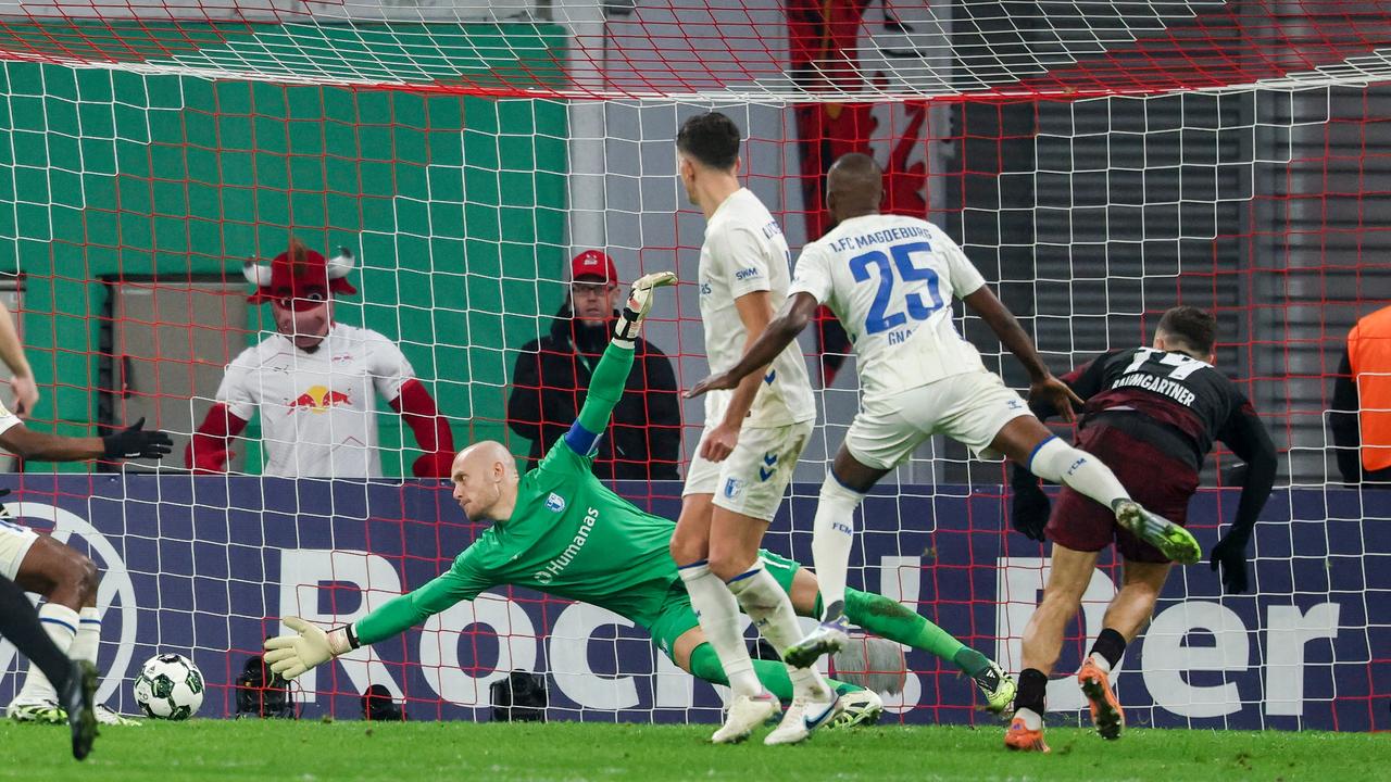 Das Bild zeigt den einen erfolgreichen Torschuss, der Torwart hechtet zwar noch in Richtung des Balls, kann ihm aber nur noch auf dem Weg ins Netz hinterherschauen.