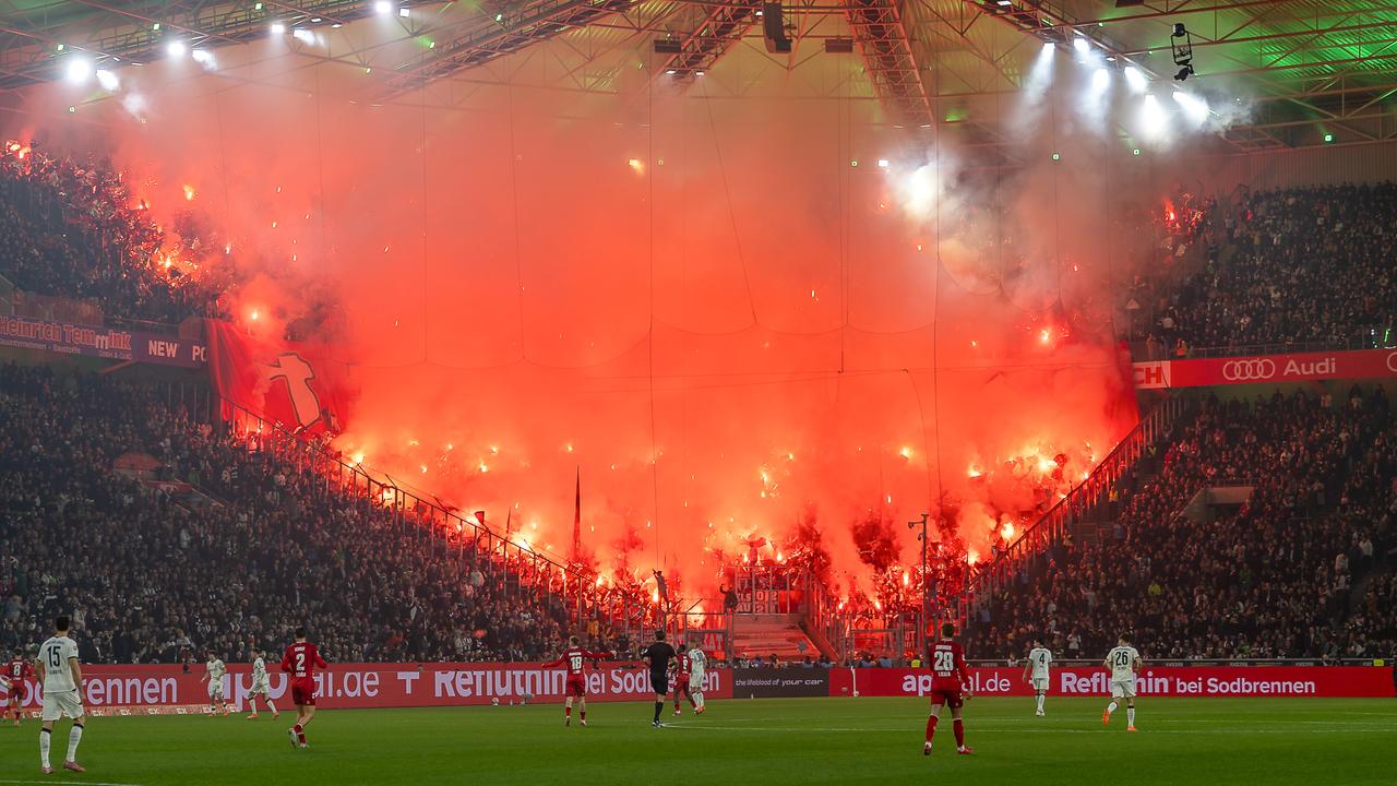 Kölner Fans haben zahlreiche Bengalos gezündet, die den Fanblock rot erleuchten lassen.