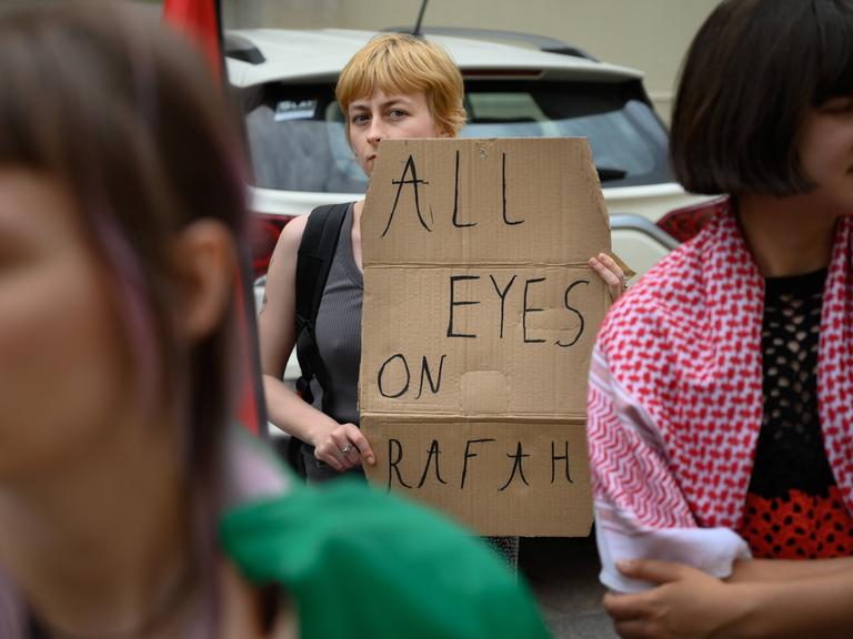 Ein junge Frau protestiert gegen den Krieg in Nahost mit einem Plakat auf dem "All eyes on Rafah" zu lesen ist.