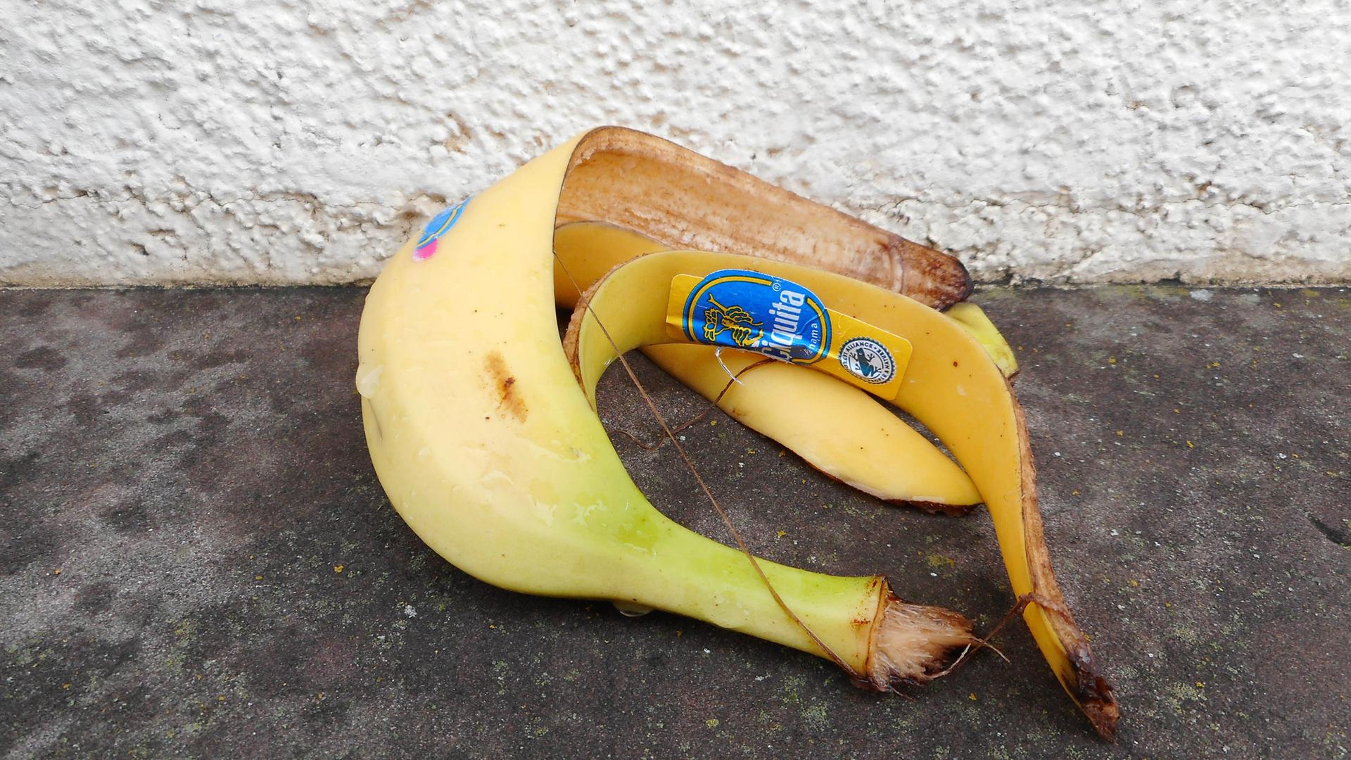 Eine Bananenschale liegt auf dem Asphalt. 