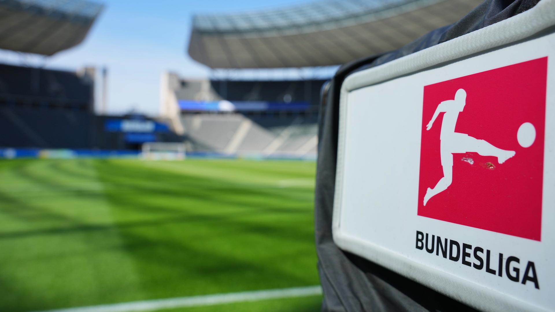 Eine TV-Kamera mit dem Bundesliga-Logo steht hinter dem Tor in einem Stadion.