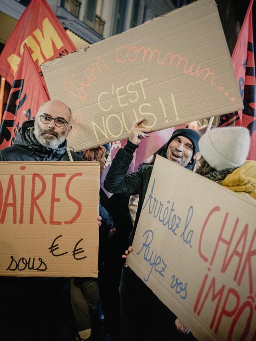 Während einer Protestaktion in Paris halten Menschen Schilder mit den Aufschriften „Milliardäre, gebt uns das Geld zurück, das Gemeinwohl sind wir" und „Hört auf mit der Wohltätigkeit, zahlt eure Steuern". Während einer Protestaktion in Paris halten Menschen Schilder mit den Aufschriften „Milliardäre, gebt uns das Geld zurück, das Gemeinwohl sind wir" und „Hört auf mit der Wohltätigkeit, zahlt eure Steuern".