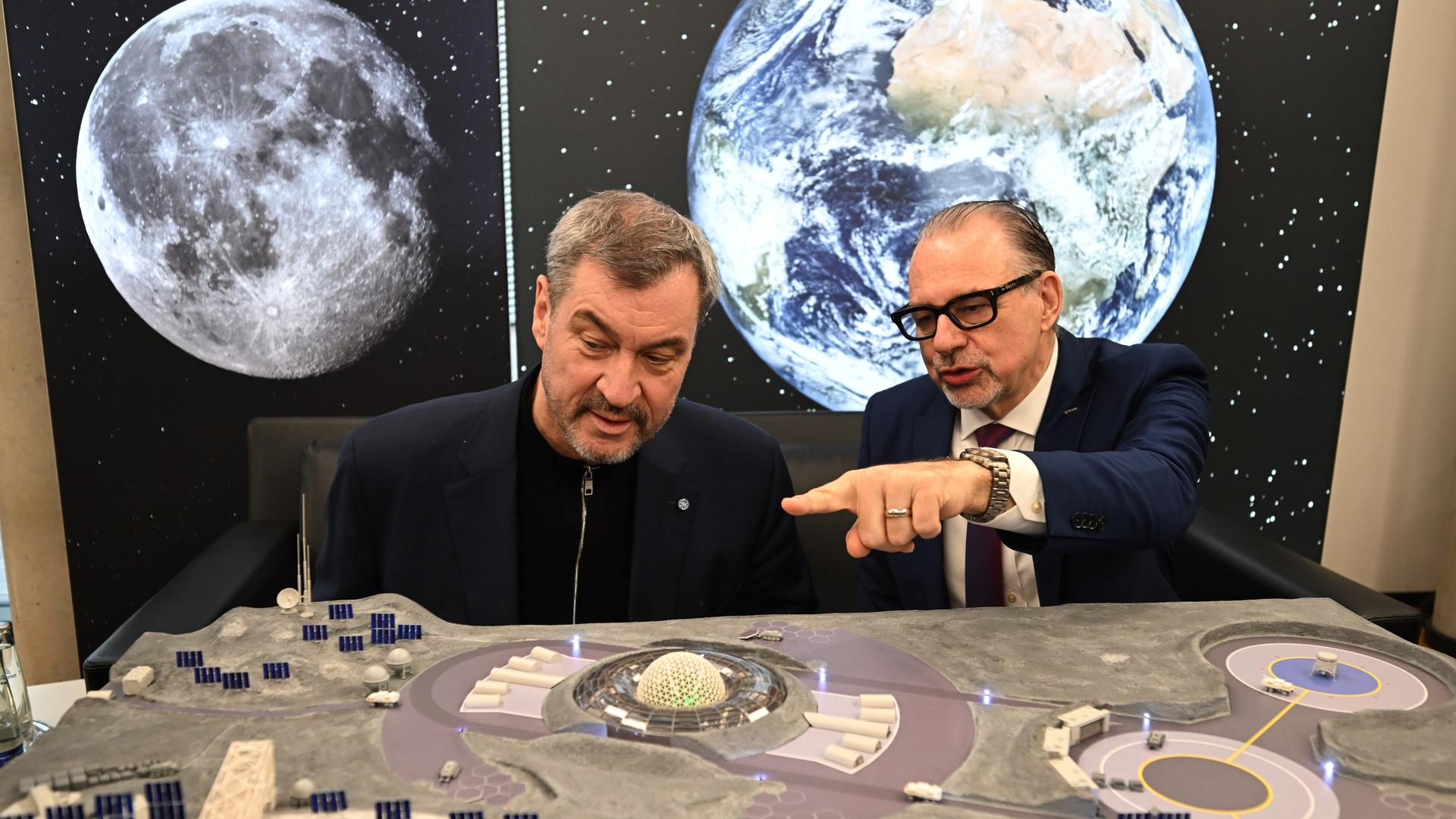 Bayerns Ministerpräsident Markus Söder und Josef Aschbacher, ESA-Generaldirektor, betrachten ein Modell einer möglichen Mondlandestation.