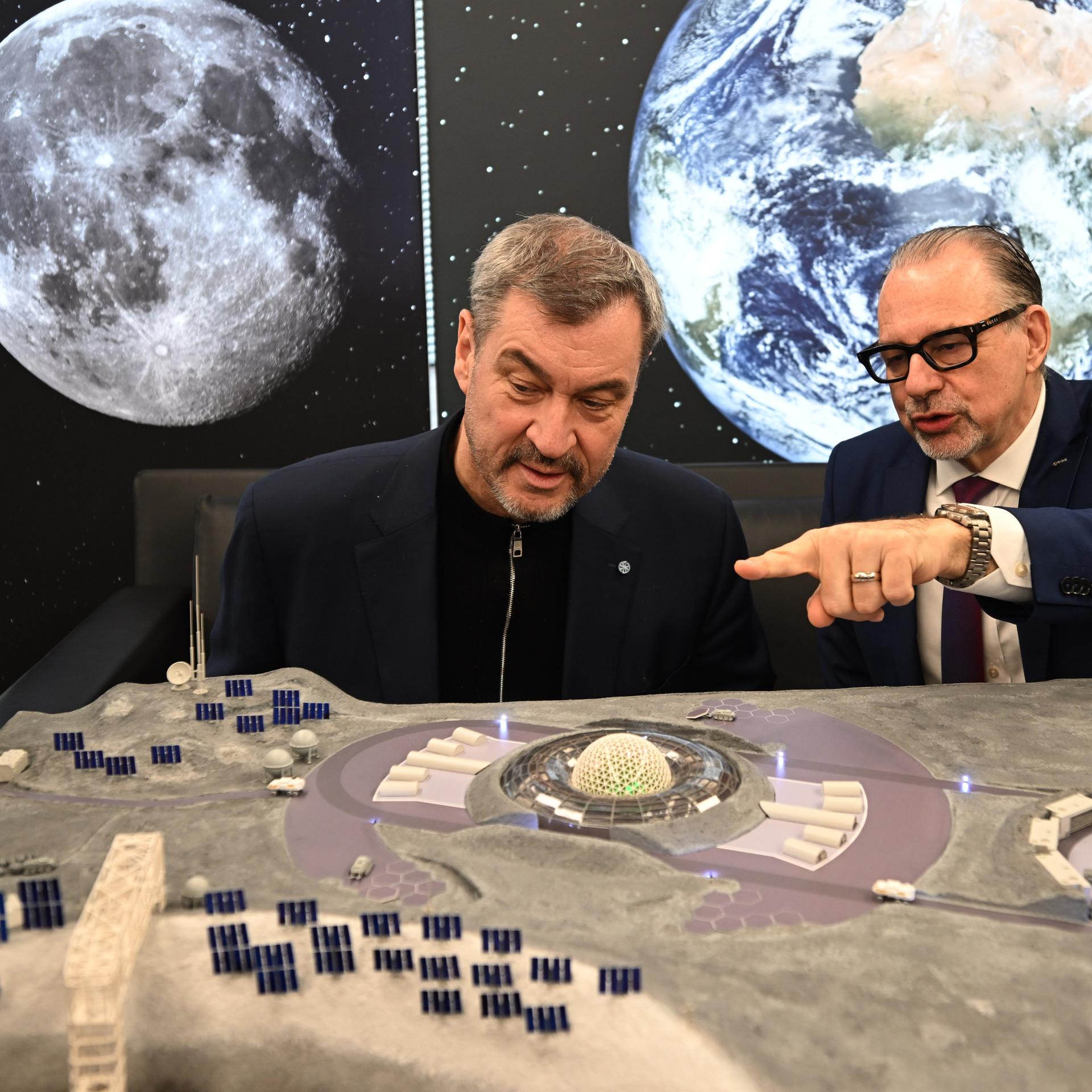 Bayerns Ministerpräsident Markus Söder und Josef Aschbacher, ESA-Generaldirektor, betrachten ein Modell einer möglichen Mondlandestation.