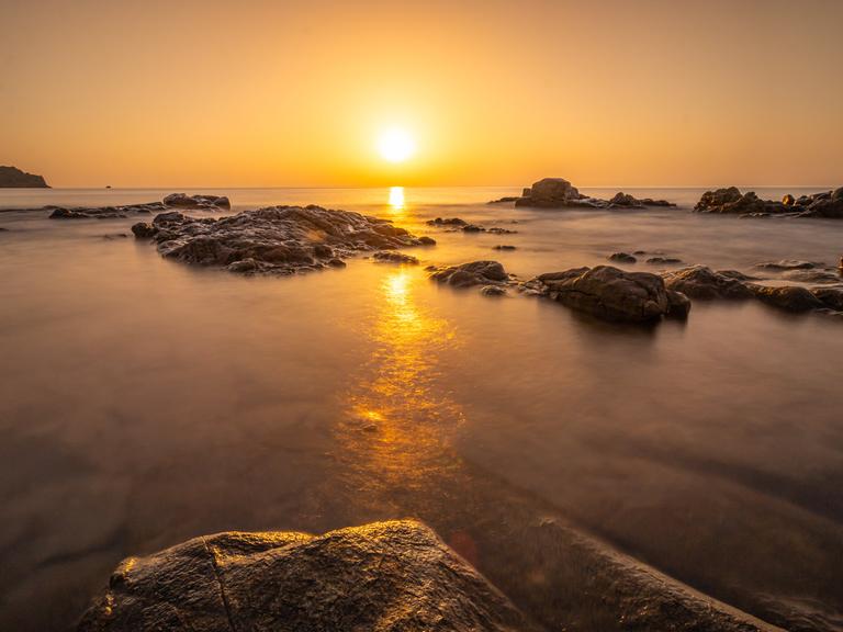Die Sonne geht auf Sardinien am Horizont über dem Meer auf. Die Sonne geht auf Sardinien am Horizont über dem Meer auf.