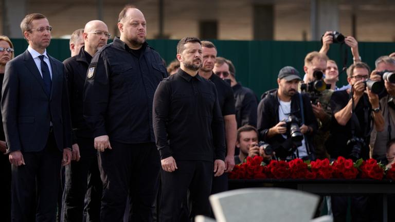 Wolodymyr Selenskyj (M), Präsident der Ukraine, nimmt auf dem Nationalen Militärfriedhof in der Nähe von Kiew an der Umbettungszeremonie für Jewhen Konowalez teil, links neben ihm Parlamentspräsident Ruslan Stefantschuk.