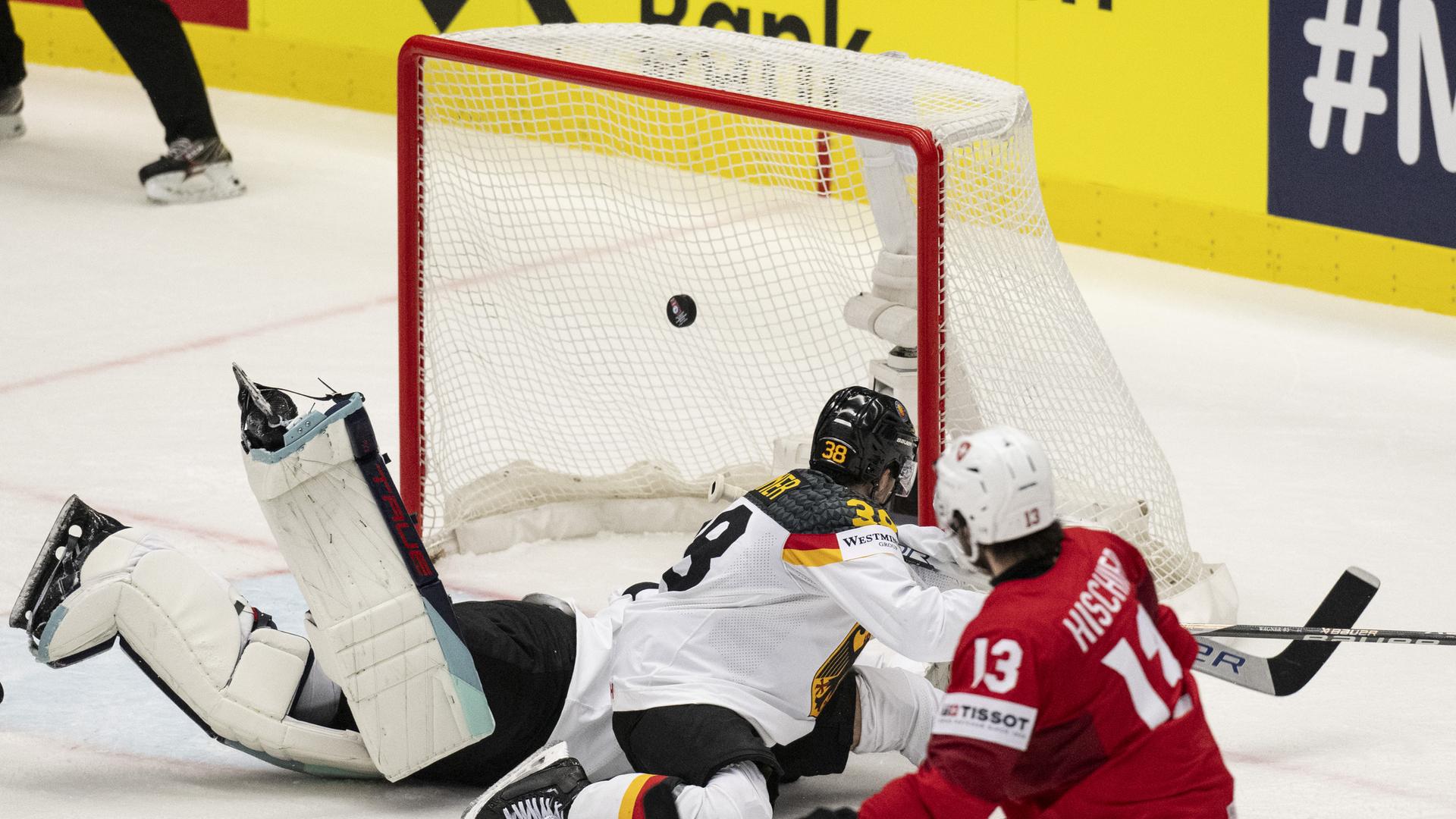 Eine Spielszene von der Eishockey-Partei Schweiz gegen Deutschland. Der Schweizer Spieler Nico Hischier, rechts im Bild, trifft den Puck ins Tor.
