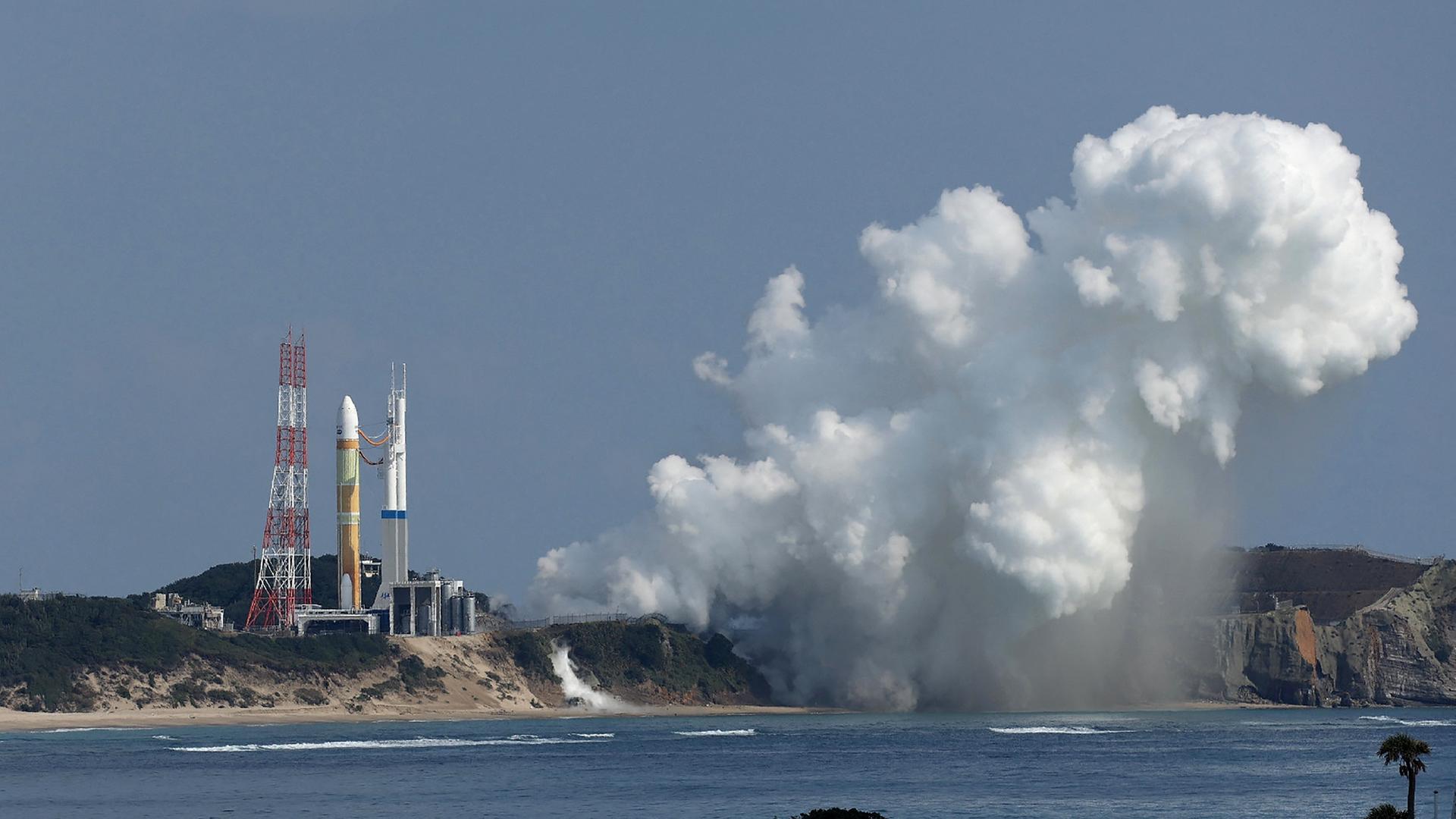 Auf einer Raketenbasis steht eine Rakete. Daneben ist eine große weiße Rauchwolke zu sehen. Auf einer Raketenbasis steht eine Rakete. Daneben ist eine große weiße Rauchwolke zu sehen.