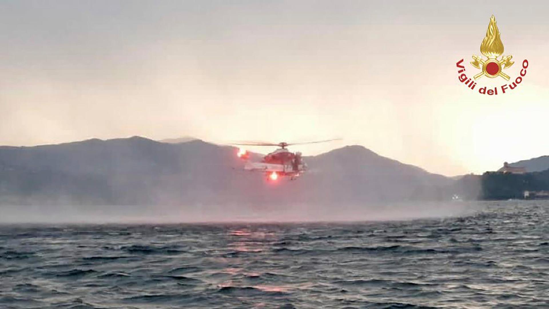 Bildschirm-Shot von einer Nachrichtensendung: Der  Hubschrauber fliegt knapp über der Wasseroberfläche und wirbelt Gischt auf. Er ist auf größerer Entfernung fotografiert.