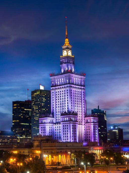 Der bläulich illuminierte Kulturpalast in Warschau im Abendlicht