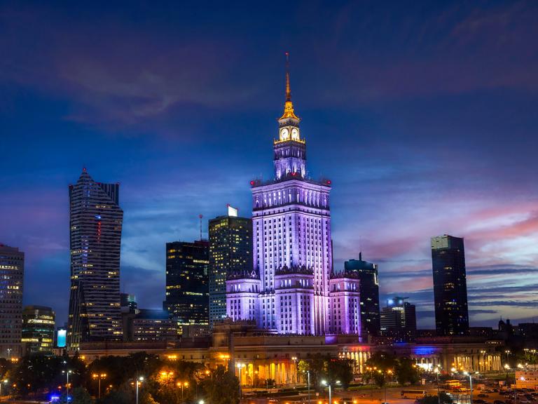 Der bläulich illuminierte Kulturpalast in Warschau im Abendlicht