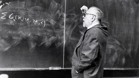 Schwarz-weiß Aufnahme von 1963 zeigt den Begründer der Kybernetik Norbert Wiener (1894-1964) vor einer Tafel mit mathematischen Formeln.