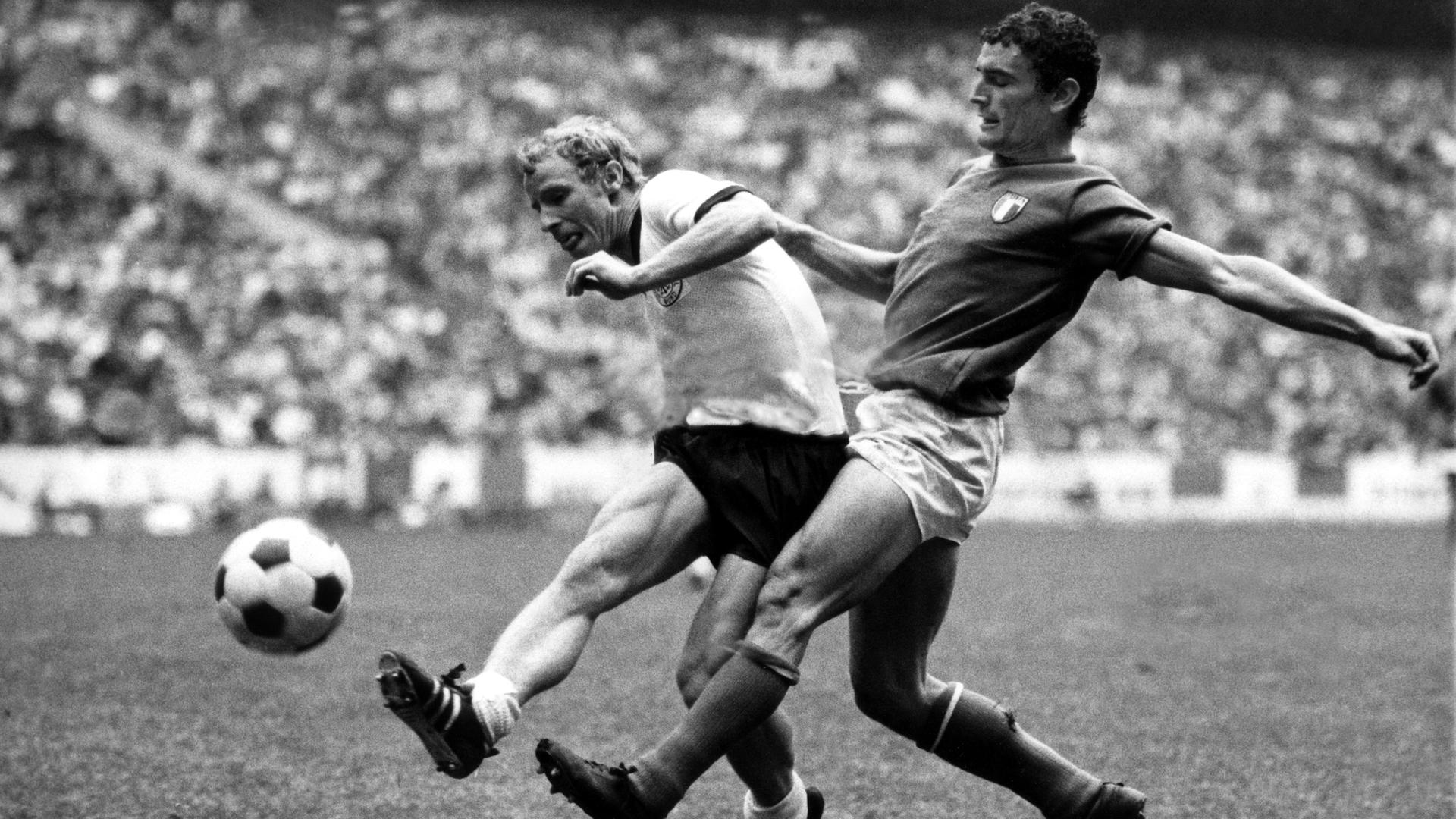 Fußball-WM 1970 in Mexiko: Der deutsche Abwehrspieler Berti Vogts (l.) wird im Schuss vom italienischen Stürmer Gigi Riva attackiert.