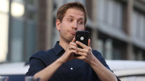 Kevin Kühnert (SPD) schaut auf sein Handy und verdreht die Augen.
