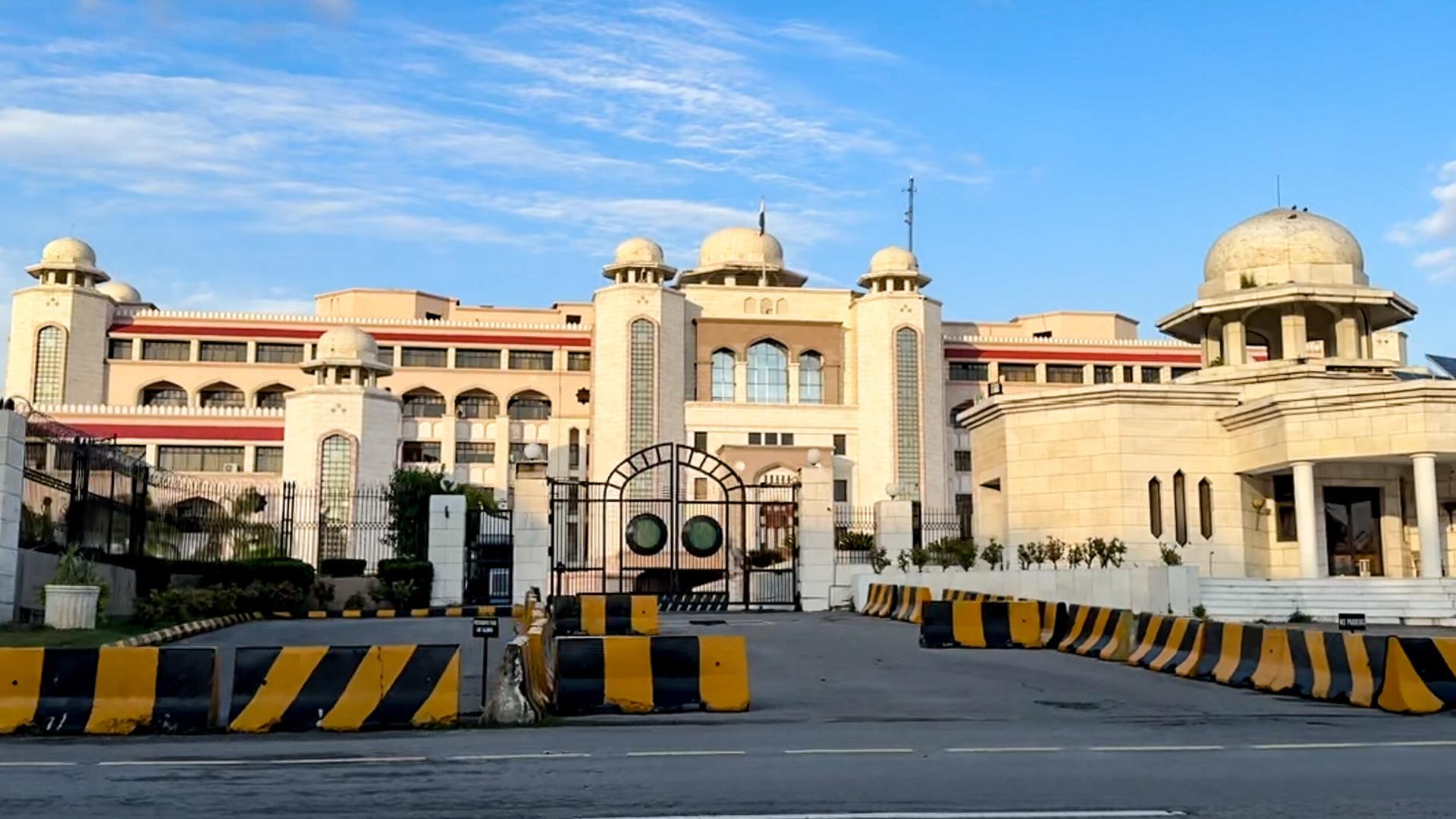 Der Sitz des pakistanischen Ministerpräsidenten, ein großes Gebäude mit heller Fassade, davor stehen Barrikaden.