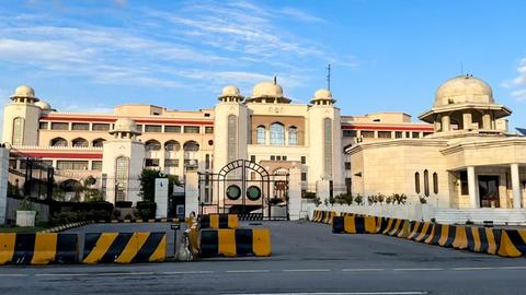 Der Sitz des pakistanischen Ministerpräsidenten, ein großes Gebäude mit heller Fassade, davor stehen Barrikaden.