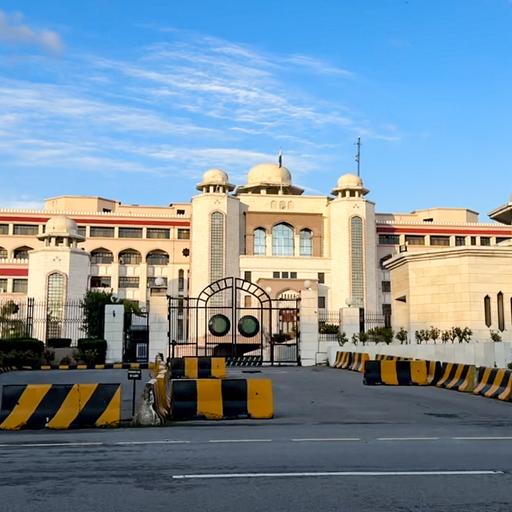 Der Sitz des pakistanischen Ministerpräsidenten, ein großes Gebäude mit heller Fassade, davor stehen Barrikaden.