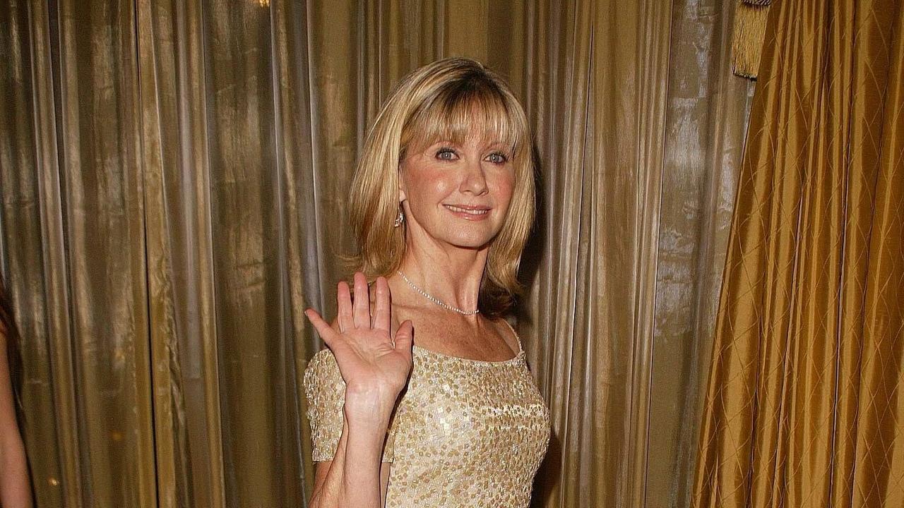 Olivia Newton-John winkt in die Kamera.