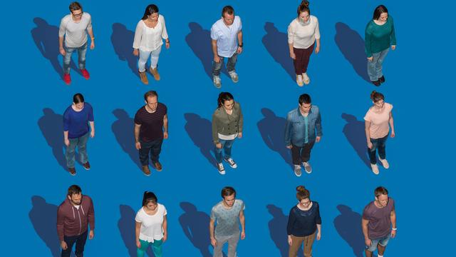 Menschen stehen vor blauem Hintergrund in einer symmetrischen Aufstellung. Menschen stehen vor blauem Hintergrund in einer symmetrischen Aufstellung.