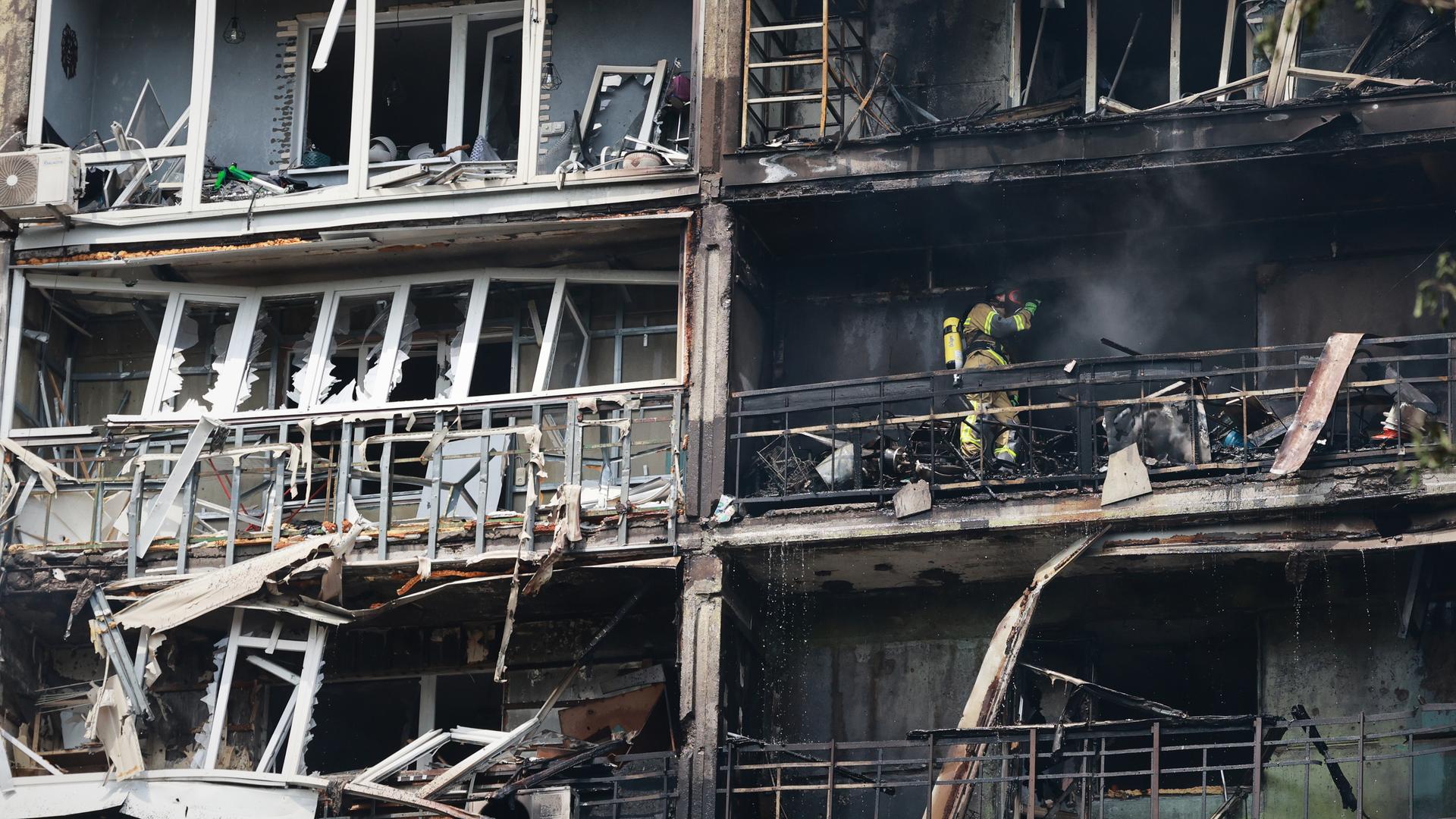 Feuerwehrleute löschen und durchsuchen ein zerstörtes Haus in Saporischschja.